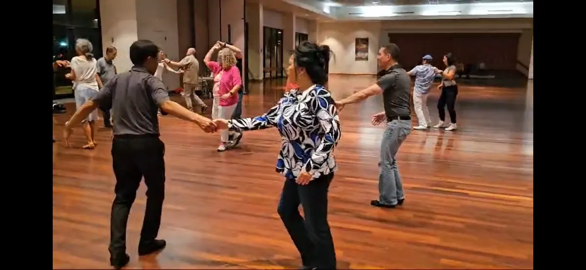 Couples dancing West Coast Swing on a crowded Palladium ballroom floor
