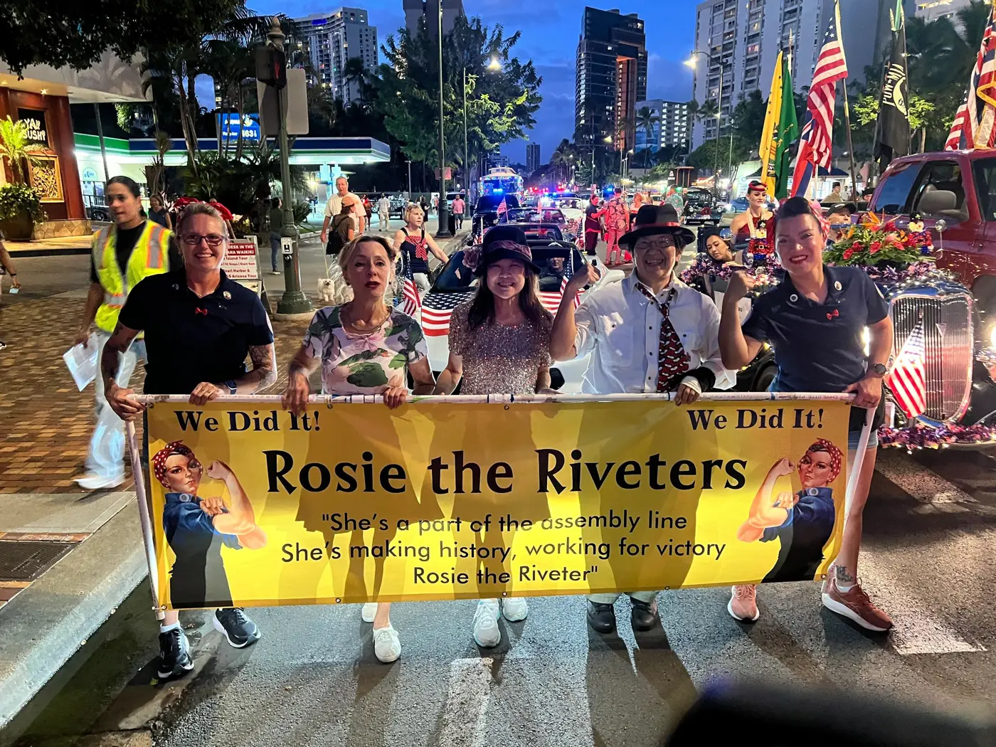 Club members marching with the Rosie the Riveters banner