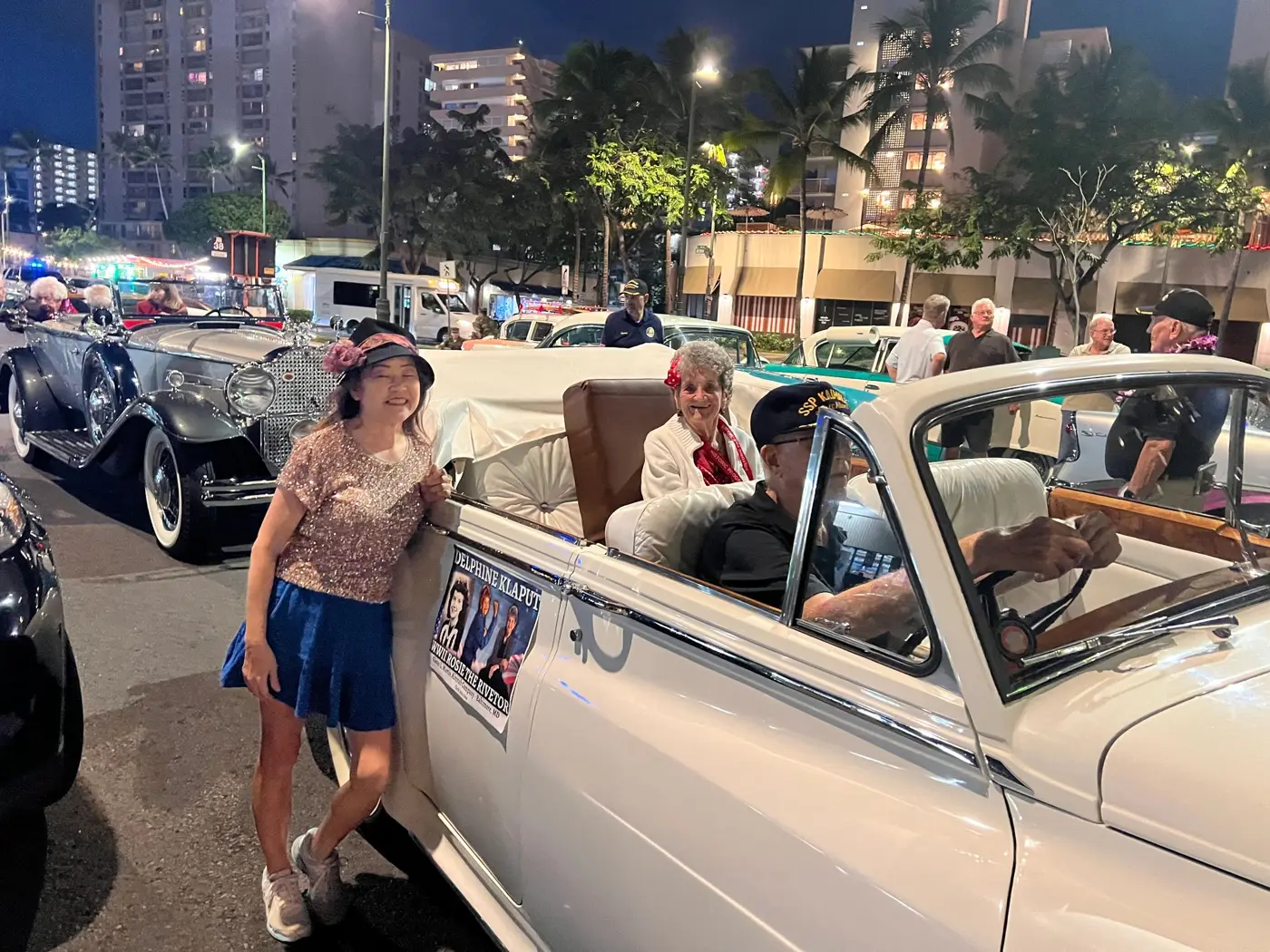 A member in vintage outfit beside a classic convertible